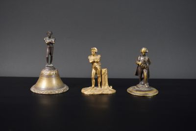 trois figurines de chevaliers et une cloche posées sur une table