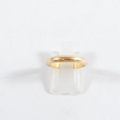 gros plan d'une bague en or sur une surface blanche