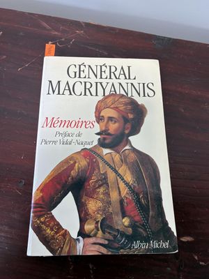 the book is sitting on a wooden table with a cigarette in it