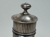 a small silver container with a lid on a table