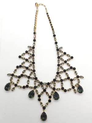 un collier imposant noir et doré orné de pierres noires