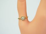yellow gold engagement ring set with a round brilliant cut diamond surrounded by a round brilliant cut diamond