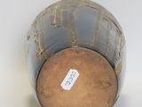 a close up of a vase with a tag on it