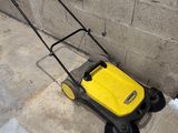 a yellow and black lawn mower sitting on the sidewalk