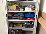 une armoire contenant de nombreux outils et une boîte posée par terre
