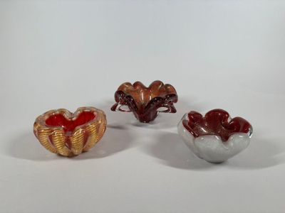 three small glass bowls sitting next to each other on a white surface