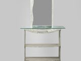 une photo d'un miroir posé sur une table, à côté d'une étagère
