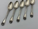 six cuillères en argent sont alignées sur une table