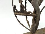 a metal sculpture of a bird on a tree branch