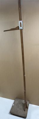 a metal pole with a wooden handle on a white table