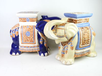 pair of blue and white ceramic elephants sitting next to each other on a white surface