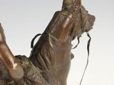 bronze statue of a man riding a horse with a saddle