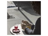 une femme assise à une table avec un verre de vin