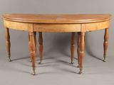 an oval dining table with two legs and a wooden top