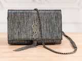 a black clutch bag sitting on top of a wooden table