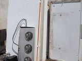 deux réfrigérateurs et un micro-ondes posés devant un immeuble