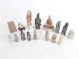 de nombreuses petites statues posées sur une surface blanche