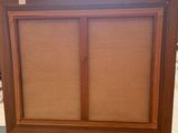 a large wooden cabinet with two doors and a window on top of it