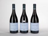 trois bouteilles de vin posées sur une table blanche