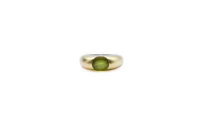 a close up of a ring with a green stone in it
