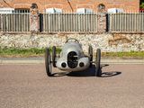 a silver race car that is parked on the street