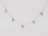 un collier avec des cristaux bleus sur fond blanc