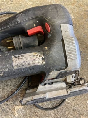 a corded jig saw on the floor next to a corded jig saw