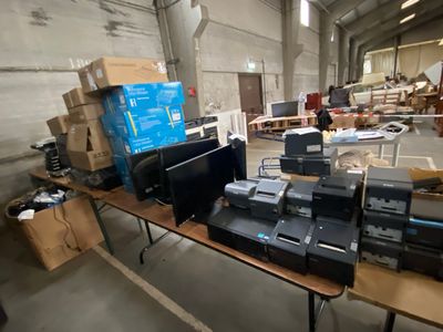 a lot of electronic equipment on a table in a warehouse