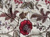 a close up of a quilt with a red flower on it
