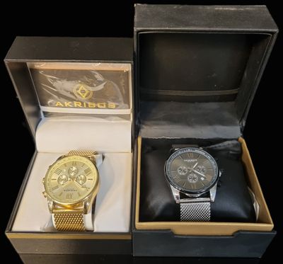 two watches sitting in a box on a black surface