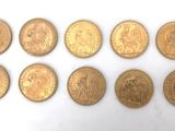six types différents de pièces d'or sur une surface blanche