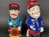 two ceramic figurines of two men with hats and beards