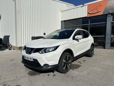 un SUV Nissan blanc garé devant un immeuble