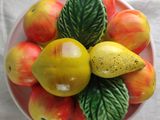 a bowl of apples and pears sitting on a table