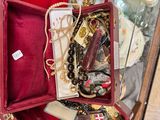 une boîte rouge remplie de nombreux bijoux posée sur une table