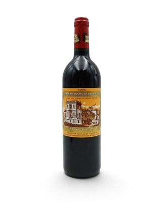 a bottle of red wine sitting on top of a white table
