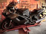 une moto posée sur un pont élévateur dans un garage