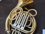 a brass french horn on a table next to other musical instruments
