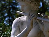 a statue of a man playing a flute in the park
