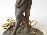 bronze statue of a woman holding a child on a rock