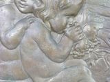 a statue of a baby holding a bunch of grapes