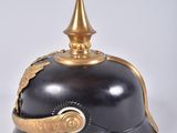 an old helmet with a gold spiked top and a black base