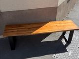 a wooden bench sitting on the sidewalk next to a building