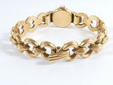 a close up of a gold bracelet on a white surface