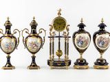 five vases and a clock on display on a table