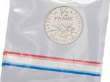 a close up of a coin in a plastic bag on a white background