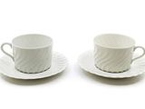 deux tasses et soucoupes posées sur une table blanche