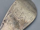 a spoon with writing on it sitting on a table
