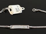 sterling bracelet with a tag and a chain on a black surface