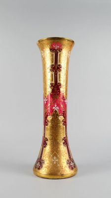 un vase en or orné d'un motif rouge